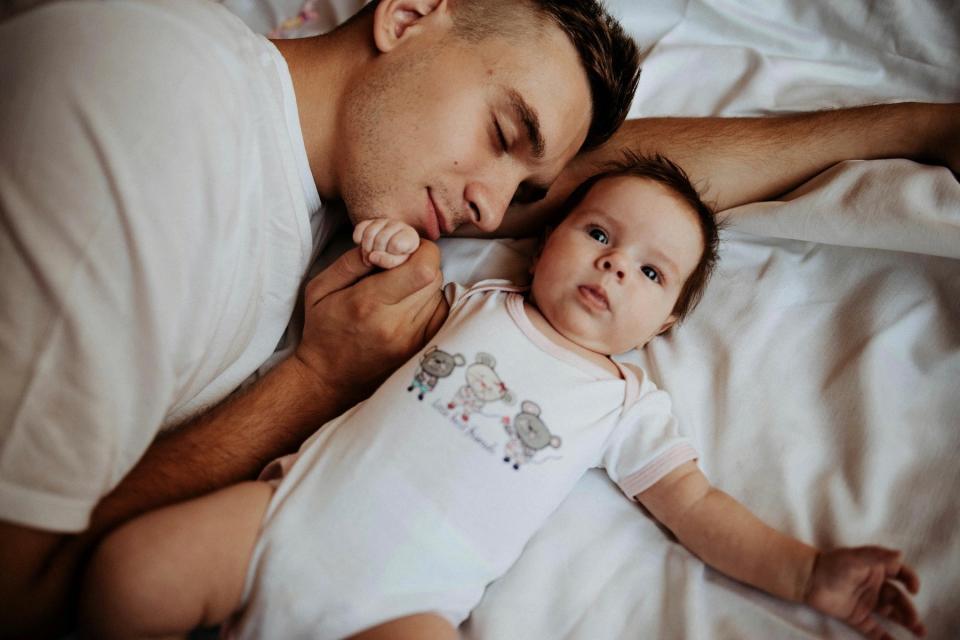 Dad laying with his baby. 